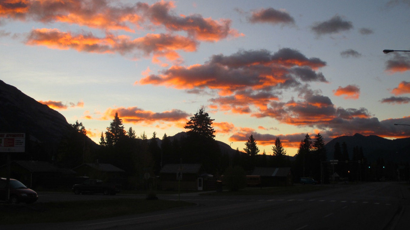 Die Sonne taucht die Wolken über Banff in ein herrliches Orange.