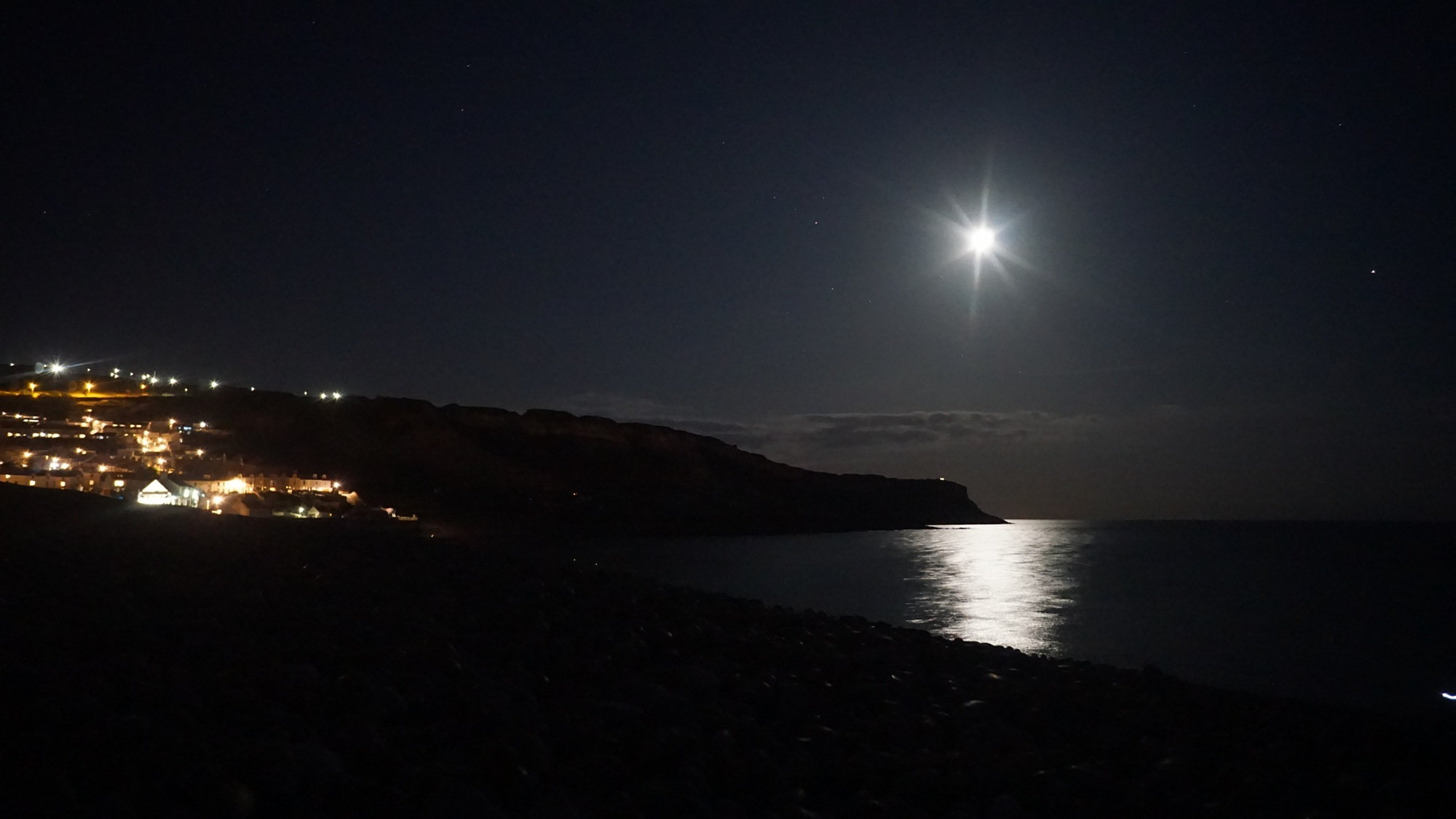 Der Mond über der Isle of Portland und dem Chesil Beach.